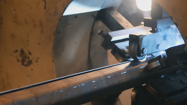 Welding robots movement in a wild for the creation of pipes.a lot of sparks, smoke and light. top view