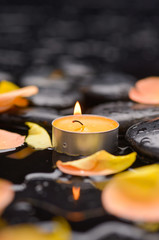 rose petals with candle and therapy stones 