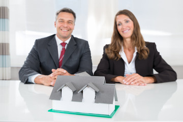 Businesspeople Looking At House Model On Desk