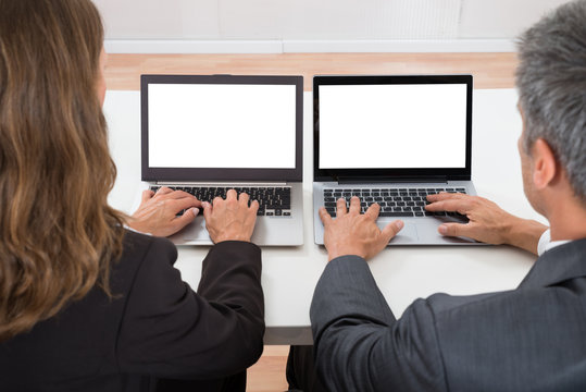 Two Colleagues Working On Laptop