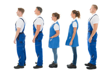 Side View Of Janitors Standing In Queue