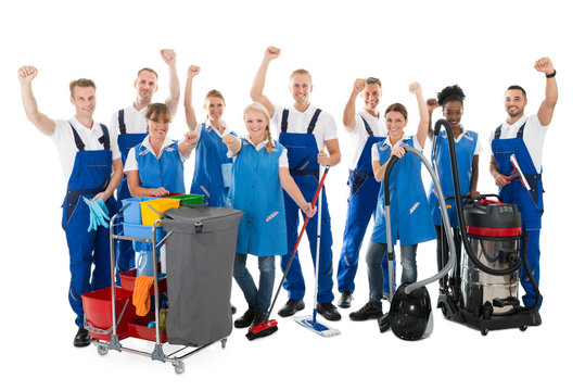 Happy Janitors With Arms Raised Holding Cleaning Equipment