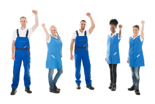 Happy Multiethnic Janitors Standing With Arms Raised