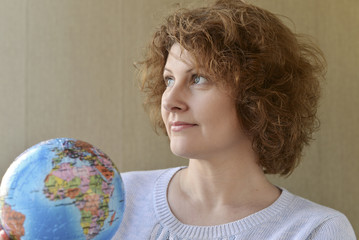 Woman with globe in hands thinking about traveling