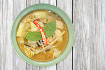 Green curry chicken with vegetable on wood table
