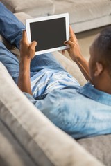Over shoulder view of casual man using tablet
