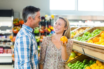 Happy smiling couple picking orange