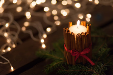 Christmas candle and ornaments over dark background with lights