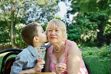 Fototapeta premium grandson hugs and kisses on the cheek his grandmother. tears in