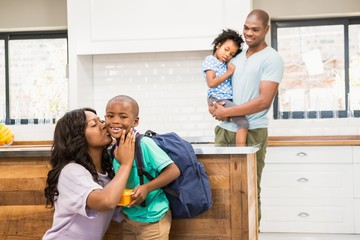 mother kissing her son going to school