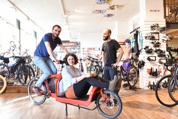 Kunden testen Transportfahrrad in einem Fahrradgeschäft // 
Customers to test transport bicycle...