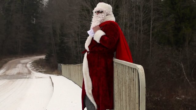 Santa Claus drink of beer bottle on the bridge