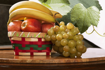 Un cesto di frutta , banana, uva, mela