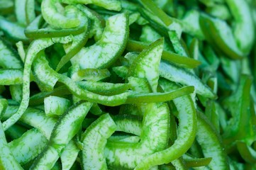 Heap of candied and dried tasty pomelo (Citrus maxima) slices with sugar for retail sale in food market. It is fruit preserves for long-term storage