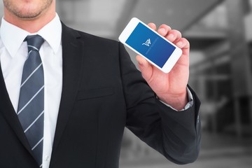 Composite image of businessman showing his smartphone screen