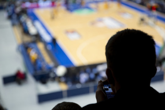 Silhouette of fan at basketball game