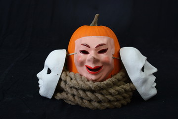 white theatrical mask with pumpkin and rope