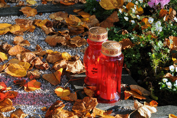 Autumn leaves and candles on the graveyard at all saints day on November 1.