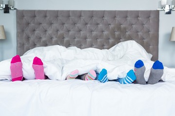 Family feet sticking out from the blanket