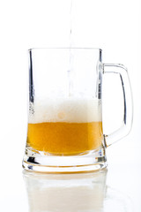 Photo of beer with reflection in glass with foam and bubbles on a white background