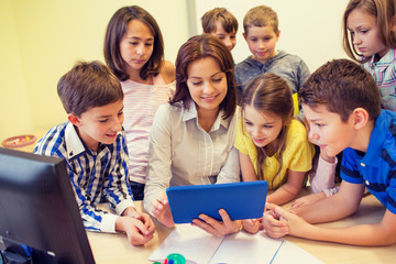 group of kids with teacher and tablet pc at school