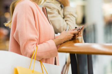 Obraz premium close up of woman with smartphone and shopping bag
