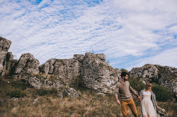 Fototapeta premium couple in the field near the mountains