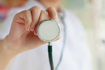 female doctor in white uniform holding stethoscope