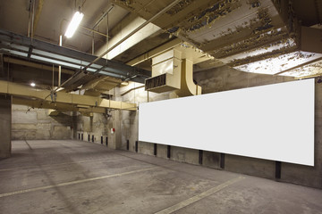 Parking garage underground interior with blank billboard