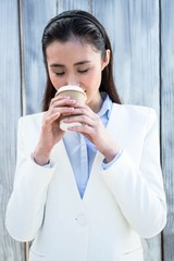 Smiling businesswoman with take-away coffee