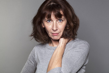 female portrait - sexy 50s woman with brown hair posing for mature wellbeing and serenity,studio shot