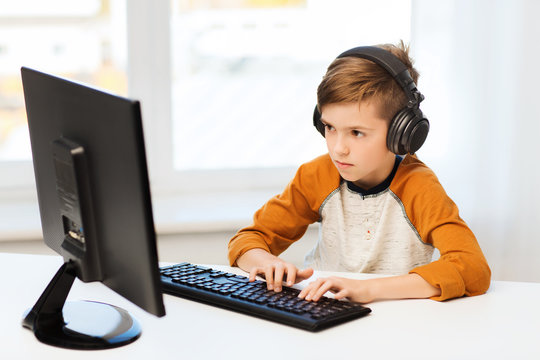 boy with computer and headphones at home