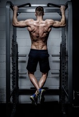 Fototapeta na wymiar Back view portrait of a muscular man tightening in The Gym's Studio