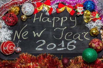 2016, Happy new year written on black background with xmas decorations