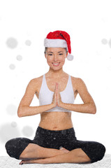 happy asian in christmas cap with snow practicing yoga