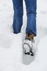 man walks through the deep snow