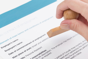 Weibliche hand stempelt den Arbeitsvertrag
