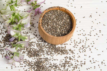 Chia seed healthy super food with flower over white wood backgro