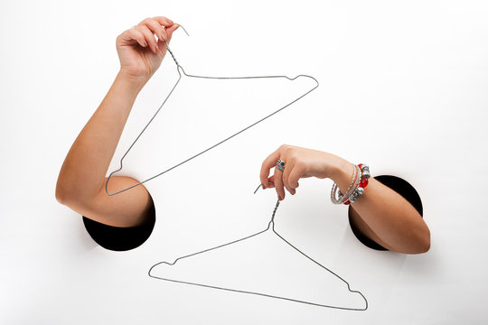 Female  hands through the holes on a white background are holdin