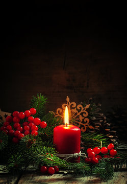 Christmas or New Year's dark composition with burning red candle