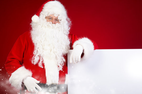 Santa Claus pointing in white blank sign with smile,christmas  