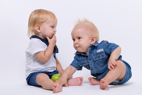 Two baby playing in the studio and eating apples