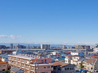Fototapeta premium Houses, mansions and a railway bridge in front of japanese mountains