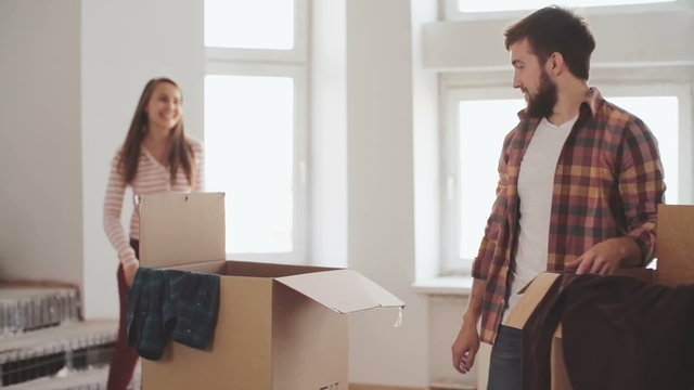 Beautiful young couple unpacking their stuff together in new apartment
