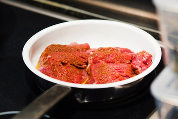 raw steak in frying pan