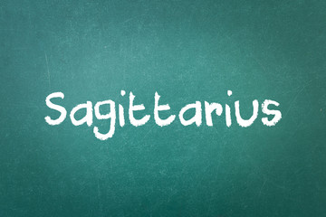 Fototapeta na wymiar Green blackboard wall texture with a word Sagittarius