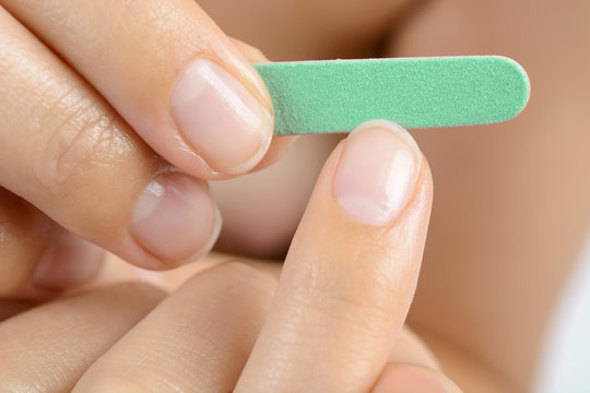 Nagelfeile feilt Fingernagel bei Nagelpflege und Manik&uuml;re 