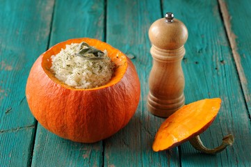 Roasted whole pumpkin with rice and meat with pepper mill