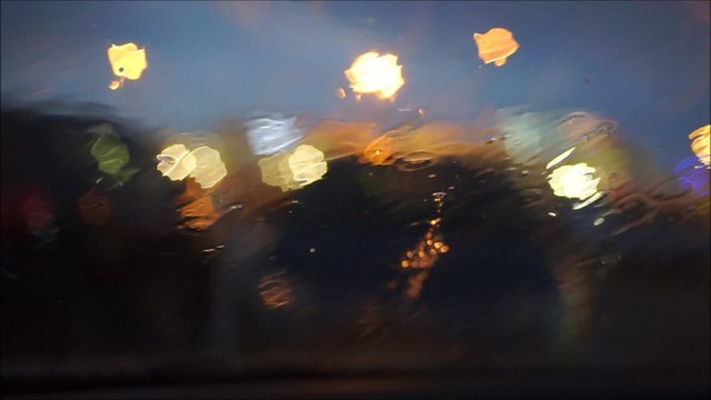 Regen prasselt bei Nacht gegen eine Windschutzscheibe oder ein Fenster &ndash; Innenaufnahme