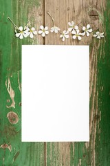 Obraz premium Flowers on vintage wooden planks with blank paper